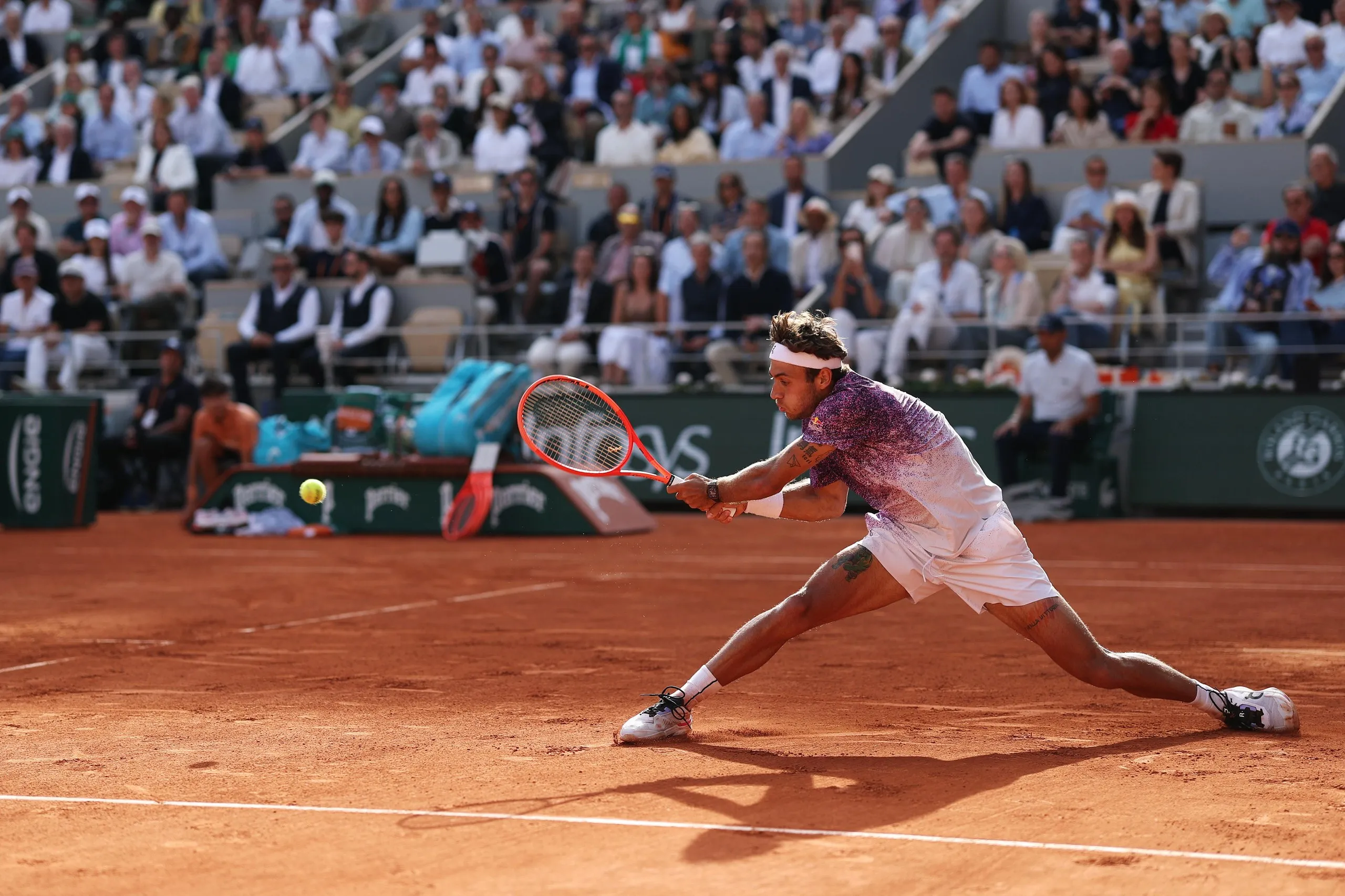 Flavio Cobolli of Italy stretches to play a backhand.