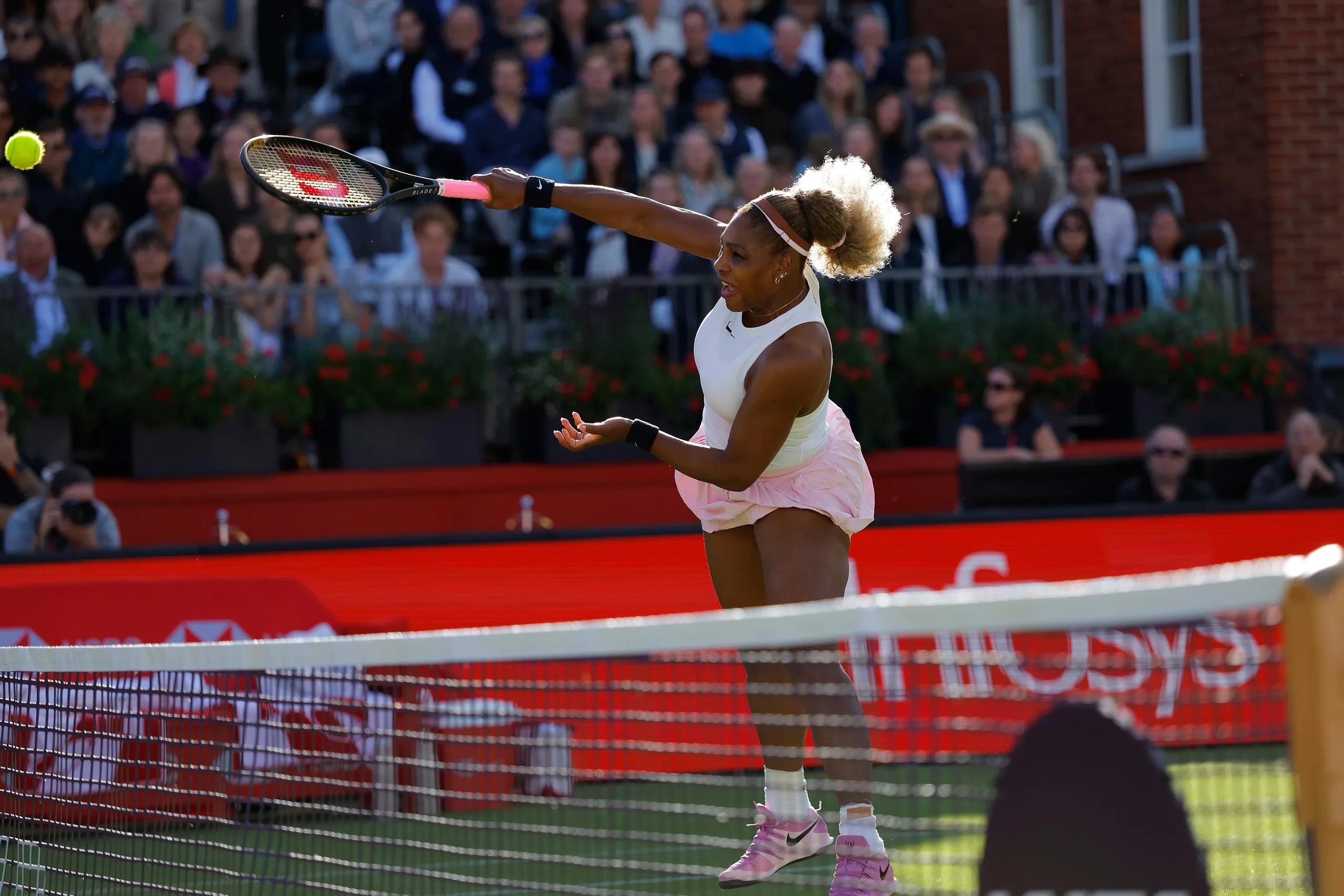 Serena Williams plays a volley at the net at Queen’s